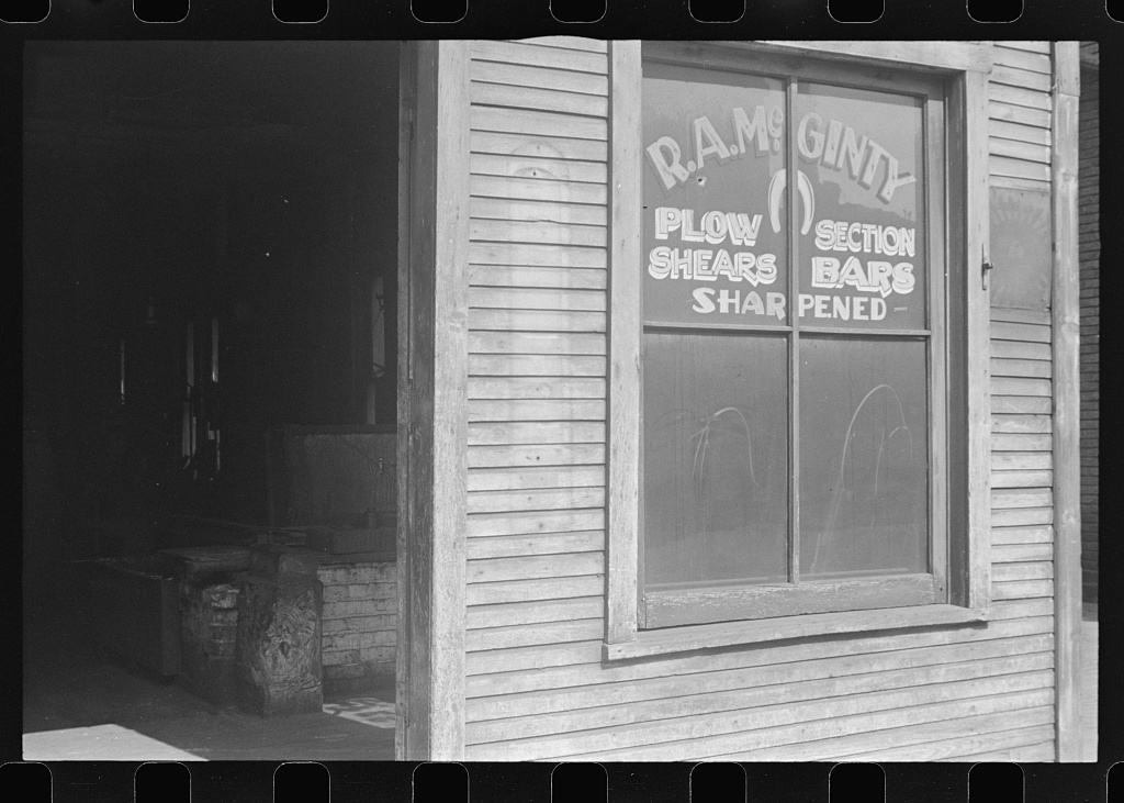 A village blacksmith shop with a hand-painted trade sign, Ohio, 1938